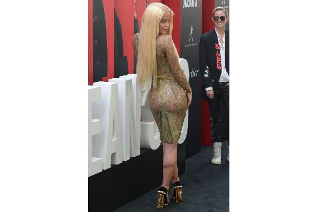 ...YouTube-Starlet Gigi Gorgeous, die derzeit keinem Blitzlichtgewitter ausweicht. Im Hintergrund grinsend steht ihre Lebens...