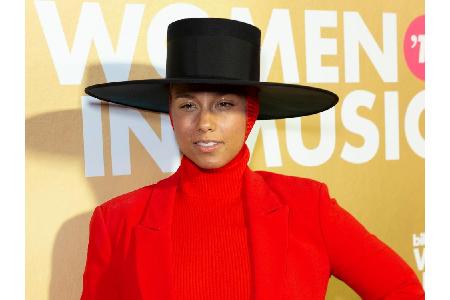 Mit diesem Look sticht Alicia Keys definitiv aus der Masse heraus. Zu ihrem scharlachroten Hosenanzug trägt die Sängerin ein...