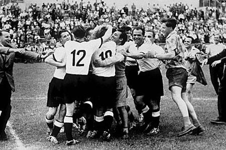 1954: Das vielzitierte Wunder von Bern. Nach dem 3:2 im Finale gegen Ungarn fallen sich die deutschen Spieler kollektiv um d...