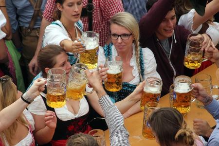 Menschen in Tracht prosten einander zu