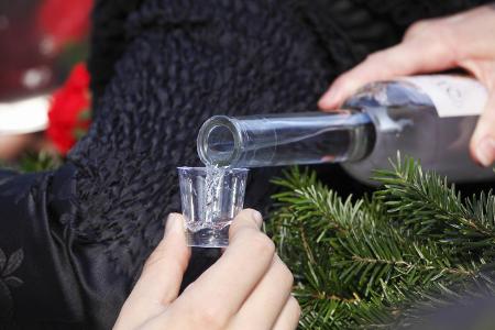 Klarer Schnaps wird in ein kleines Glas geschenkt