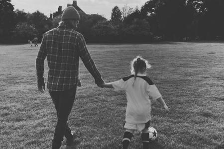 Hand in Hand dribbeln David Beckham (42) und seine Tochter Harper (6) mit einem Ball über das Spielfeld.