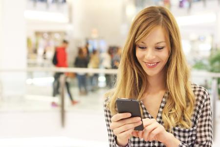 Frau vergleicht Preise über das Smartphone