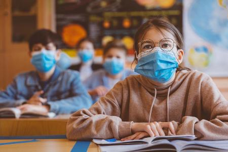 Schülerinnen und Schüler mit OP-Masken im Unterricht