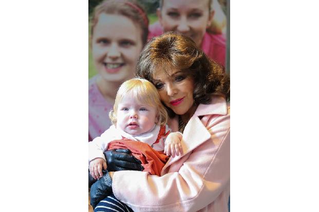 ...es Joan Collins offensichtlich besonders angetan. Das Baby wird erstmal ordentlich gekuschelt! Später...