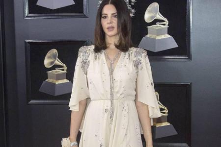 Eine cremefarbene Robe mit silbernen Verzierungen von Gucci präsentierte Lana Del Rey.