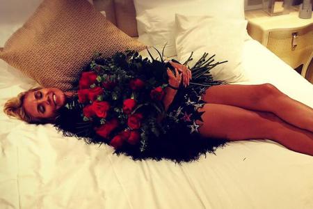 Wenn das Model mal keinen Hund neben sich liegen hat, dann badet sie eben in den Rosen ihres Partners, Vito Schnabel.