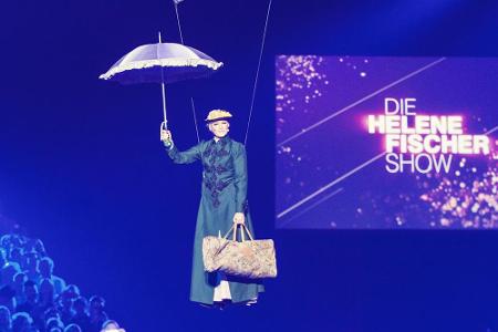 Eines der vielen Highlights: Helene Fischer als Mary Poppins. Bewaffnet mit einem Schirm schwebt die Sängerin über die Bühne.