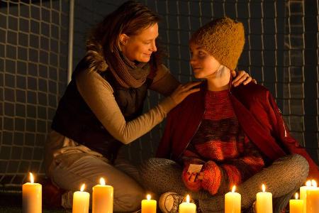 Tina Baumann (Sarah Mahita, r.) hat Kerzen aufgestellt und Fußballbilder für Hannes bei sich, Dessen Mutter Esther (Katharin...