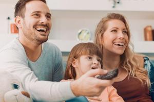 Eine junge Familie gemeinsam vor dem Fernseher