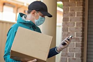 Ein Paketzusteller mit Schutzmaske