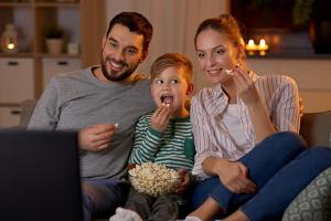Eine junge Familie bei der abendlichen Unterhaltung vor dem TV