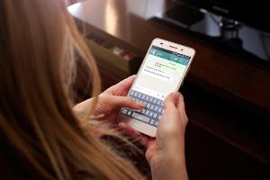 Eine junge Frau benutzt WhatsApp (Symbolbild)