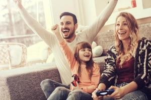 Eine junge Familie, die gemeinsam Videospiele spielt