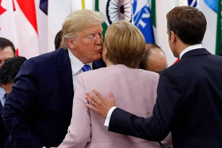 Donald Trump drückt Angela Merkel einen Schmatzer auf die Wange