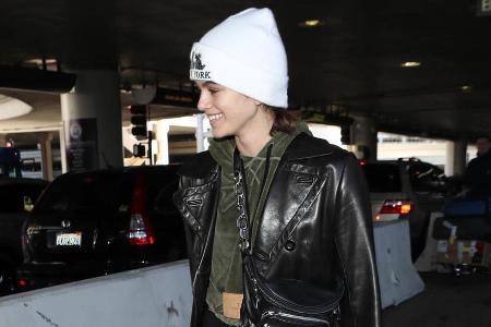 Model Kaia Gerber setzt auf eine weiße Mütze zu einem dunklen Outfit