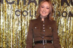 Olivia Wilde kombiniert auf der New York Fashion Week eine Military-Jacke mit einem schimmernden Rock im Animal Print