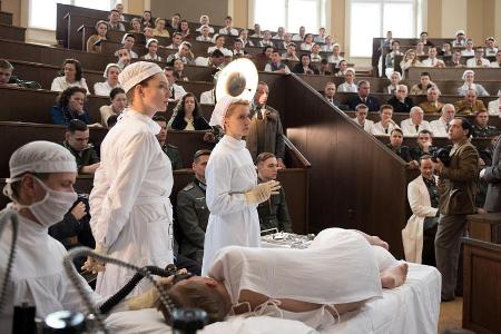 Margot Sauerbruch (Luise Wolfram, l.) und Schwester Christel (Frida-Lovisa Hamann, 2.v.l.) bei einer OP im Hörsaal der Charité