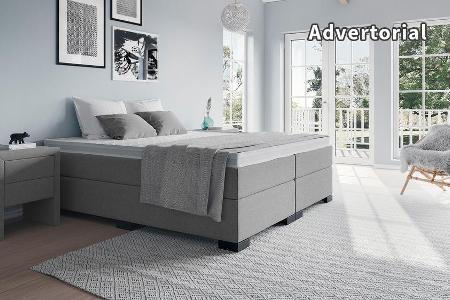 Ein Boxspringbett mit einer Matratze und zwei Unterboxen