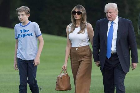 US-Präsident Donald Trump (v.r.) geleitet Ehefrau Melania und Sohn Barron zum Weißen Haus