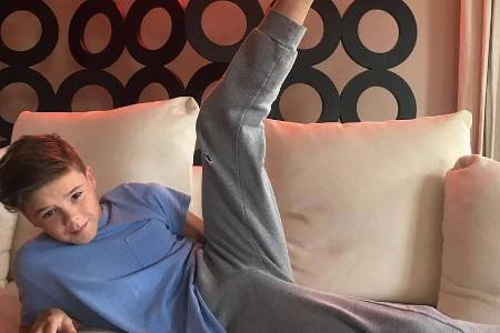 Verzweifelt versucht Cruz Beckham sein Bein so hoch zu strecken, wie Mama Victoria