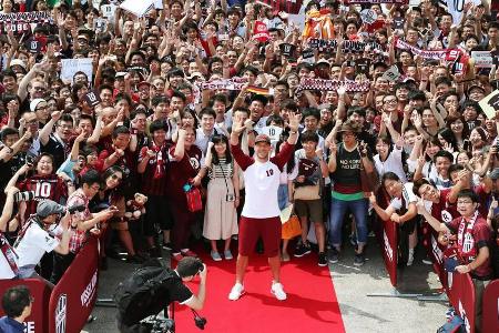Lukas Podolski nimmt ein Bad inmitten seiner japanischen Fans