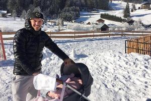 Lukas Podolski schiebt den Kinderwagen mit seiner Tochter durch den Schnee