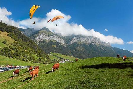 Gleitschirmflieger am Bergmassiv La Tournette über dem Col de la Forclaz