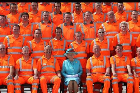 Sie sucht die Nähe zum Volk: Nach Eröffnung eines Bahnhofs posiert die Königin mit den Arbeitern.