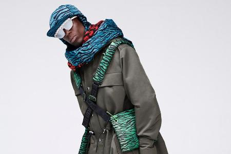 Oko Ebombo trägt diverse Accessoires mit Tigerprint und einen khaki-farbenen Mantel