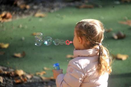 ...nicht genug konnte die Dreijährige von den Seifenblasen bekommen, die in dem warmen Herbstlicht noch bunter erschienen. I...