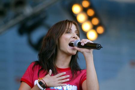 In welcher Hand hält hier Natalie Imbruglia ihr Mikrofon?