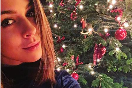 Sängerin Vanessa Mai schickte Weihnachtsgrüße in einem blauen Samt-Oberteil und mit roten Christbaumkugeln im Hintergrund.