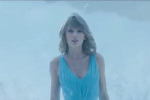 Im blauen Kleid schreitet Taylor Swift durch eine Schneelandschaft