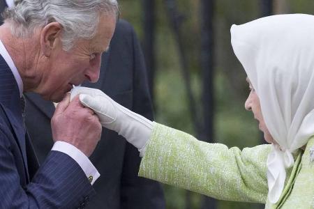 Prinz Charles, der älteste Sohn der Queen, gibt seiner Mutter einen Handkuss.