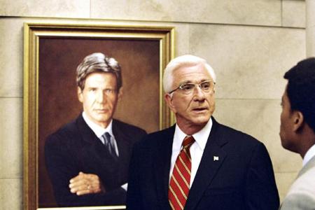 Leslie Nielsen als US-Präsident vor einem Abbild seines Vorgängers: Harrison Ford