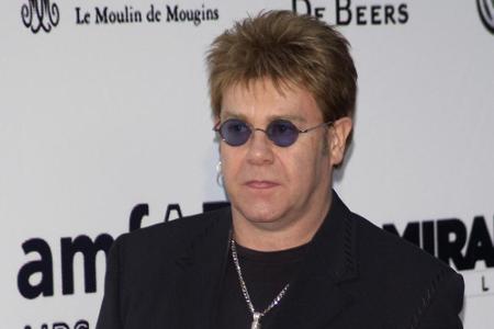 Ozzy Osbourne, bist du's? Im schwarzen Anzug mit Kruzifix und runder Sonnenbrille sieht Elton John dem 
