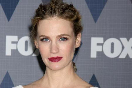 Schauspielerin January Jones bevorzugt zum weißen Cocktail-Kleid locker nach hinten geflochtene Braids.