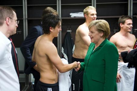 Angela Merkel in der Kabine der DFB-Elf mit Mesut Özil