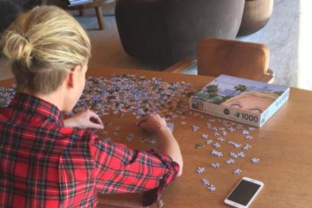 Ellen DeGeneres schaut ihrer Frau Portia beim Puzzeln über die Schulter