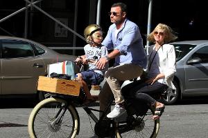 Birkenstock, Schulterpolster und Pilotenbrille - Schauspielerin Naomi Watts stilsicher auf einem Rad mit Mann und Sohn