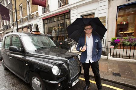 Taron Egerton vor dem Taxi, das ihm und Colin Firth in 