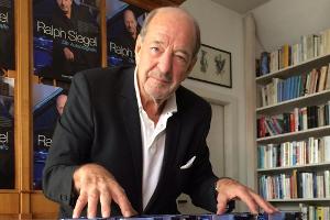 Zur Freude der Fotografen gab Ralph Siegel ein kleines imaginäres Klavier-Konzert auf seinen Büchern