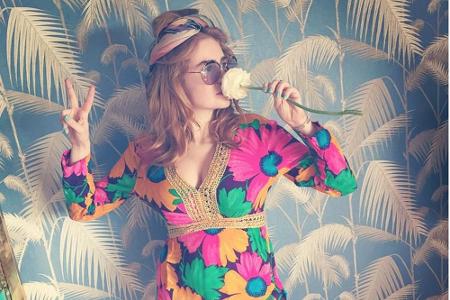 Das Multi-Talent ist hin und weg vom neuen Hippie-Look. Palina entspannt vor Palmentapete im Blumen-Dress mit Pusteblume in ...