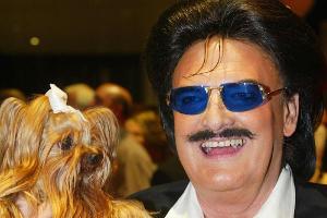 Rudolph Moshammer, wie man ihn zu Lebzeiten kannte: Mit Lächeln im Gesicht und Daisy auf dem Arm