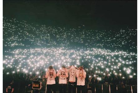 Cro (2. v. r.) und seine Band posieren vor einem leuchtenden Publikum in der Olympiahalle in München