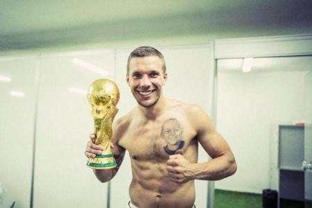 Lukas Podolski mit Pokal und Tattoo