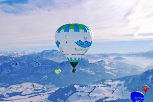 Bunte Heißluftballone am Himmel über der Region Kaiserwinkl