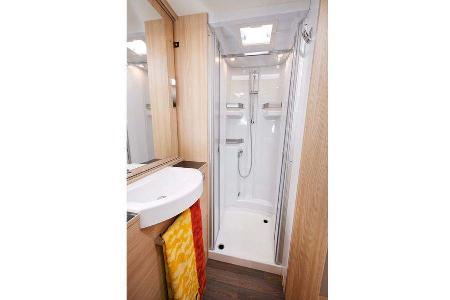 Die Dusche mit Ablagen und abnehmbarer Kleiderstange.