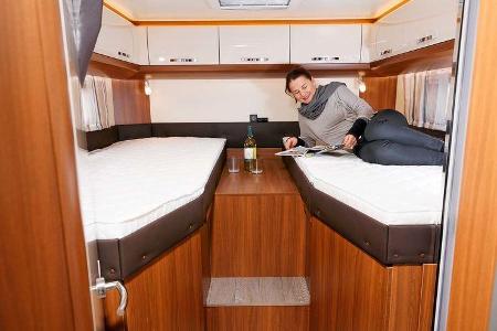 Große holzfarbene Ablage zwischen den Betten wirkt etwas karg und ungemütlich im Hobby Optima